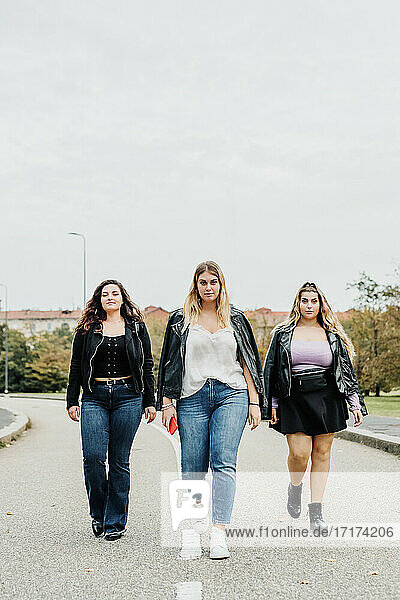 Three young women walking in road
