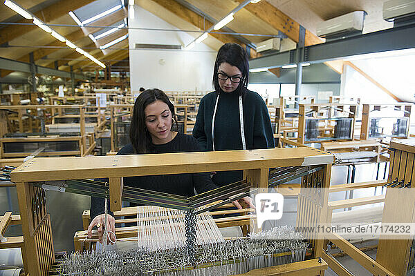 Studenten beim Weben am Webstuhl in der Textilwerkstatt