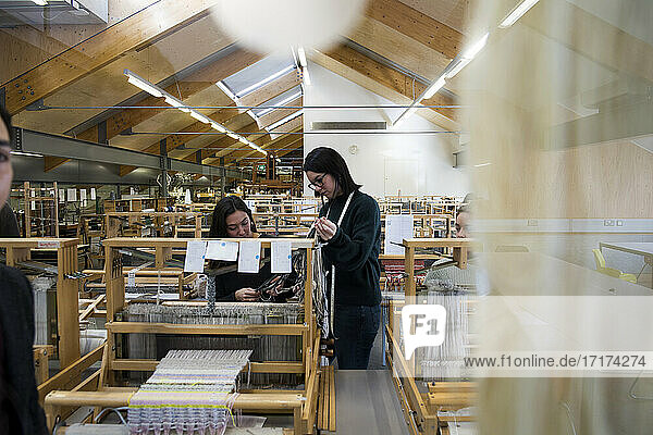 Modestudenten am Webstuhl in der Textilwerkstatt