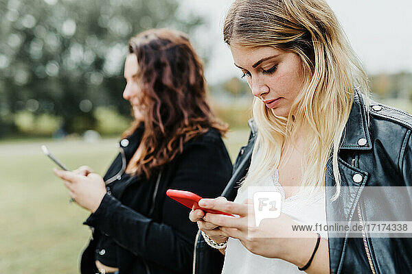 Zwei junge Frauen schauen auf ihre Telefone