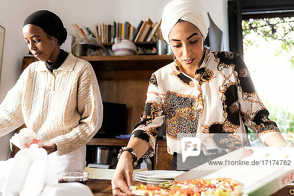 Junge Frauen bei der Zubereitung von Essen zum Mitnehmen