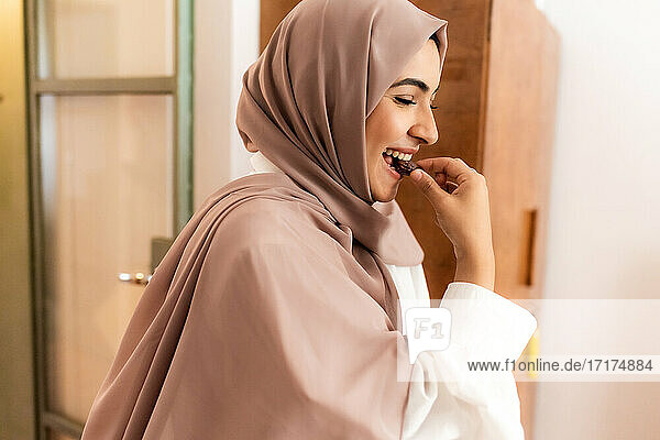 Junge muslimische Frau isst Dattel zum Fastenbrechen