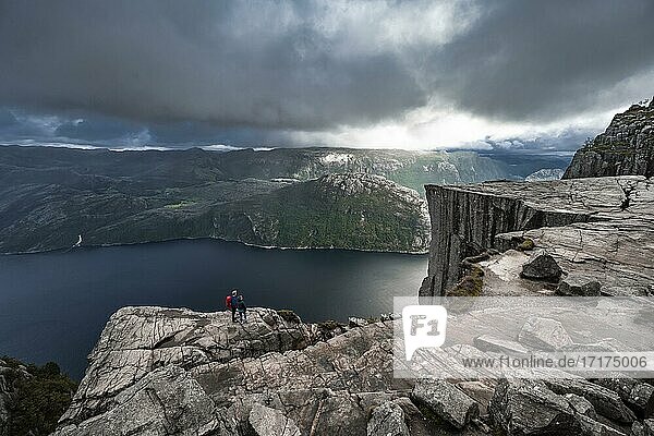 Two (hikers) in front of rock plateau  Preikestolen rock spire  Lysefjord  Ryfylke  Rogaland  Norway  Europe