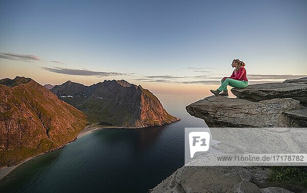 Abendstimmung  Wanderin auf dem Gipfel des Ryten  Meer  Kvalvika Strand und Berge  Fredvang  Lofoten  Nordland  Norwegen  Europa