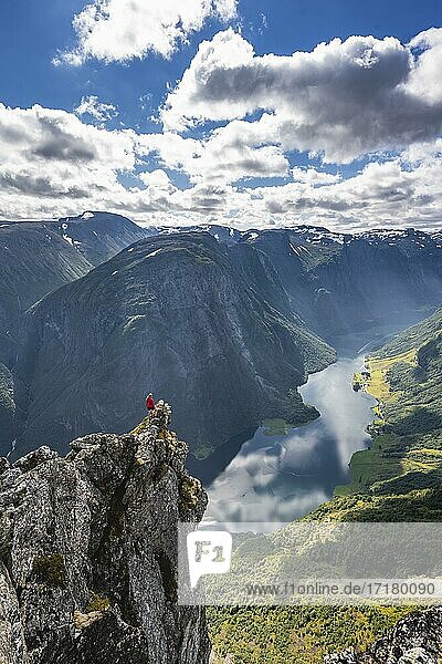 Wanderin steht auf Felszunge  Grat  Blick vom Gipfel des Breiskrednosi  Berge und Fjord  Nærøyfjord  Aurland  Norwegen  Europa