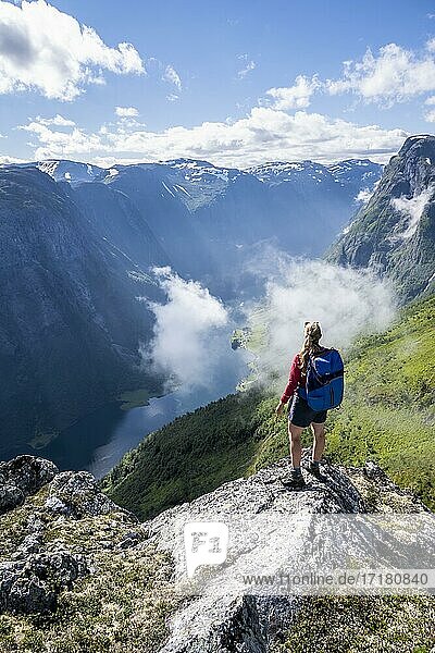 Wanderin blickt ins Tal  Blick vom Gipfel des Breiskrednosi  Berge und Fjord  Nærøyfjord  Aurland  Norwegen  Europa