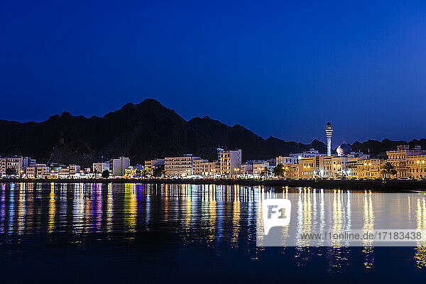 Die Stadt Muscat  Lichter am Wasser  Berge dahinter  bei Nacht