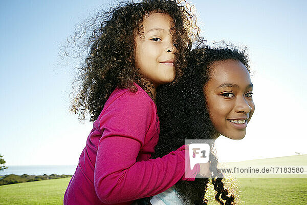 Junge gemischte Rasse Mädchen geben eine jüngere Schwester ein Huckepack