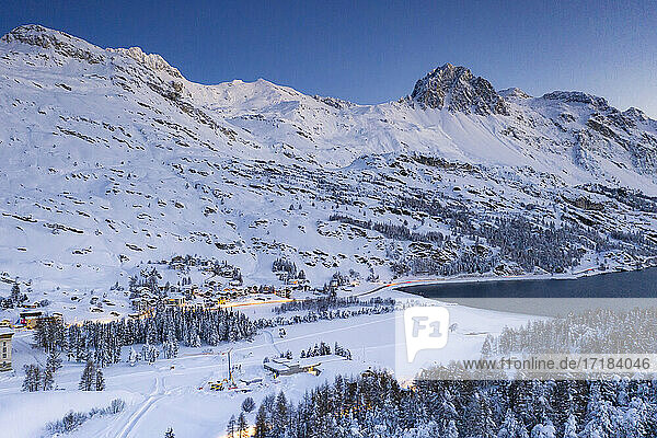 Dämmerung über dem verschneiten Dorf Maloja am Ufer des Silser Sees  Bergell  Engadin  Kanton Graubünden  Schweiz  Europa