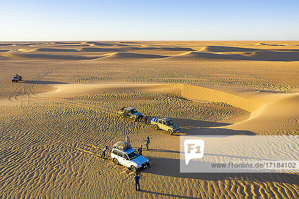 Luftaufnahmen von Autos  die durch die Sanddünen der Tenere-Wüste fahren  Sahara  Niger  Afrika