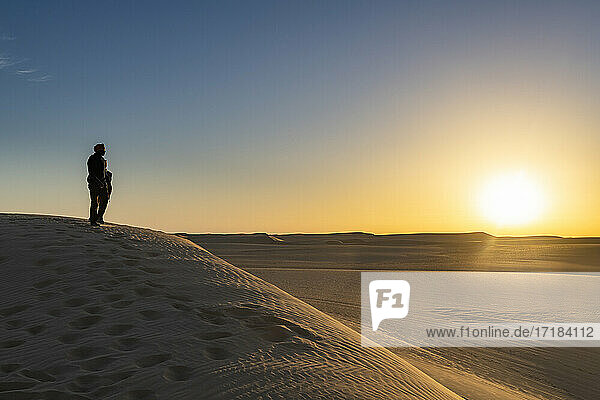 Tuareg stehend auf einer Sanddüne in der Tenere-Wüste bei Sonnenaufgang  Sahara  Niger  Afrika