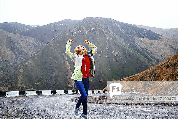 Travelling woman dances on the mountain road