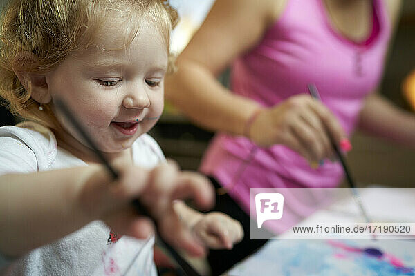 Glücklich lächelnd niedlichen kleinen Mädchen malen mit Pinsel