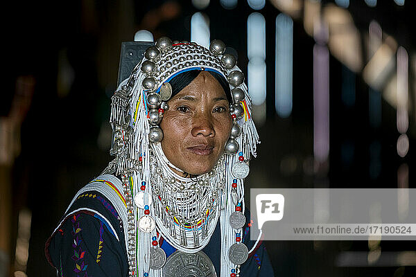 Kopfbild einer lächelnden Frau vom Stamm der Akha in ihrem Haus  in der Nähe von Kengtung  Myanmar