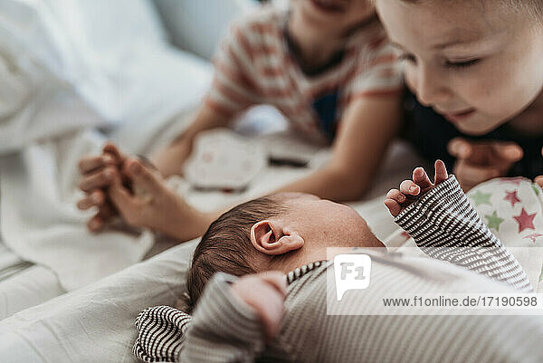 Neugeborener Junge trifft seine großen Brüder zum ersten Mal im Krankenhaus