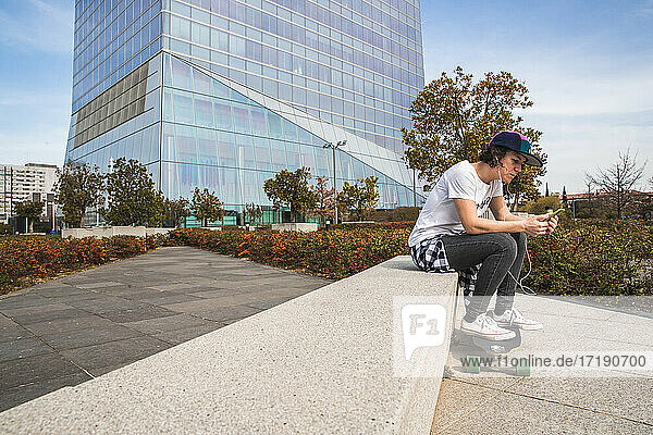 Frau mit Mütze sitzend mit Skateboard