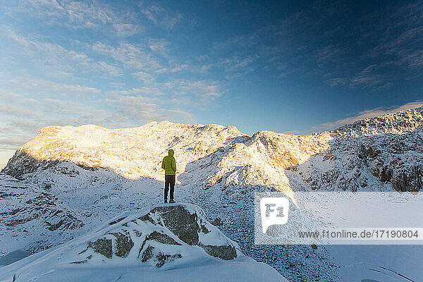 Mann steht auf einem felsigen Bergkamm  Blick auf eine malerische Bergkette