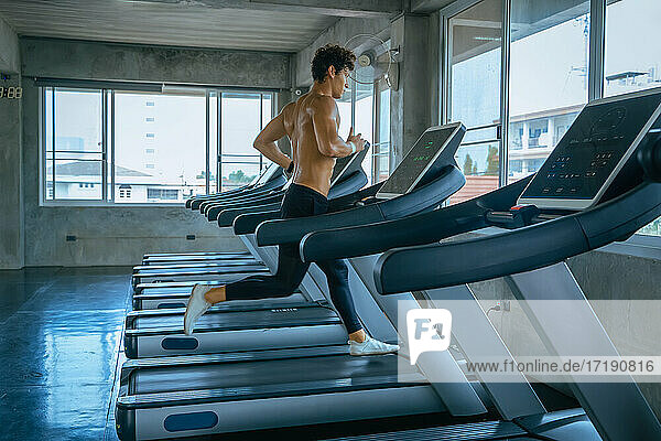 Man running in machine treadmill at fitness gym sport  fitness E