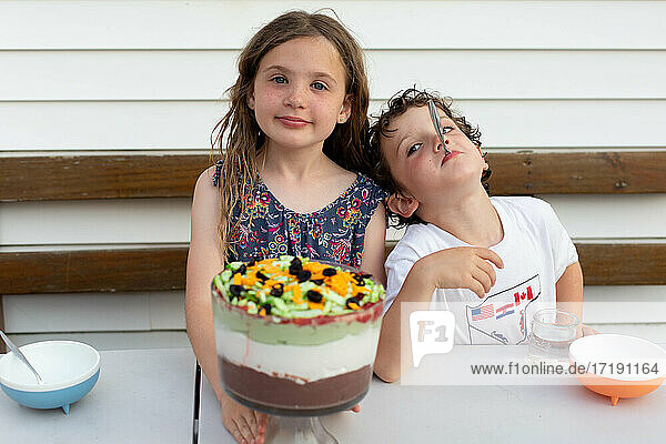 Siblings eating dessert in their backyard