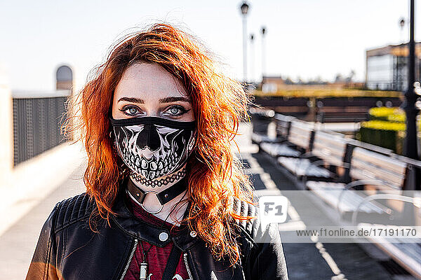 Portrait of gothic girl with orange hair and skull face mask