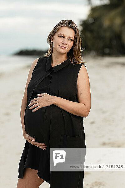 Weiße schwangere Frauen am weißen Strand am Meer