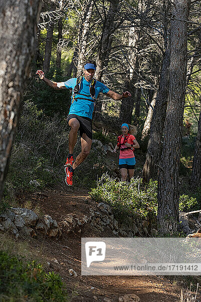 Man and woman running on mountain trail  Calpe  Costa Blanca  Alicante