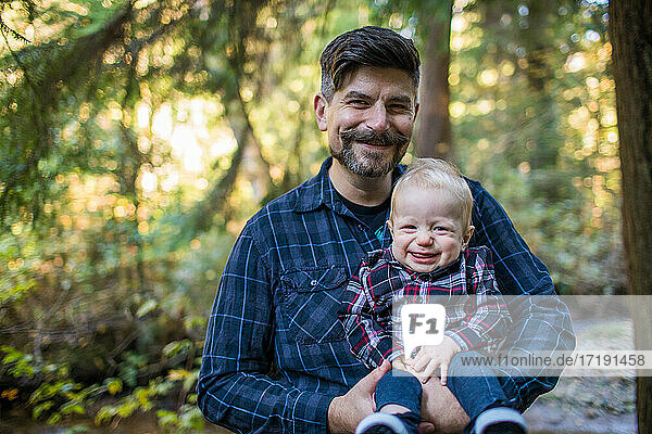 Father and son  smiling together outdoors.