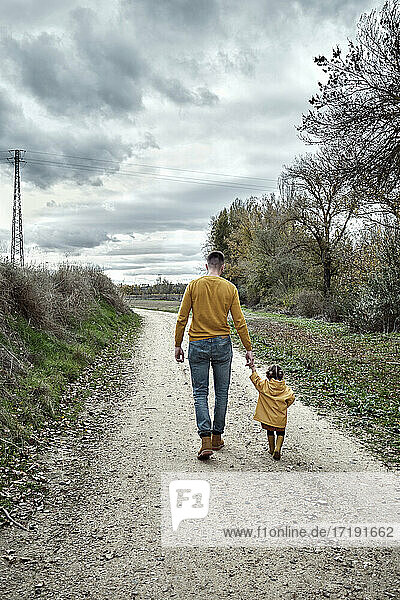 Ein zweijähriges Mädchen geht mit ihrem Vater spazieren