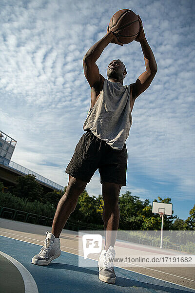 Muskulöser afroamerikanischer Mann  der auf dem Basketballplatz punktet