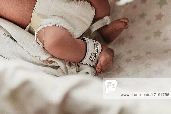 Nahaufnahme der Füße eines Neugeborenen mit Krankenhausarmband nach der Geburt