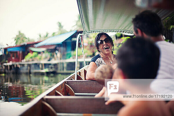 Lachende Frau auf einem Boot auf einem schwimmenden Markt in Bangkok Thailand.