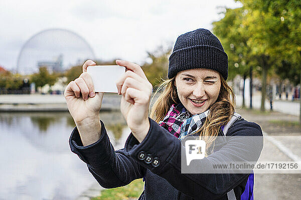 Female solo traveler taking photo with smartphone