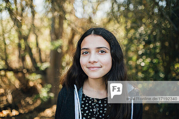 Außerhalb Porträt eines jungen Teenager-Mädchen mit einem süßen geschlossenen Mund Lächeln