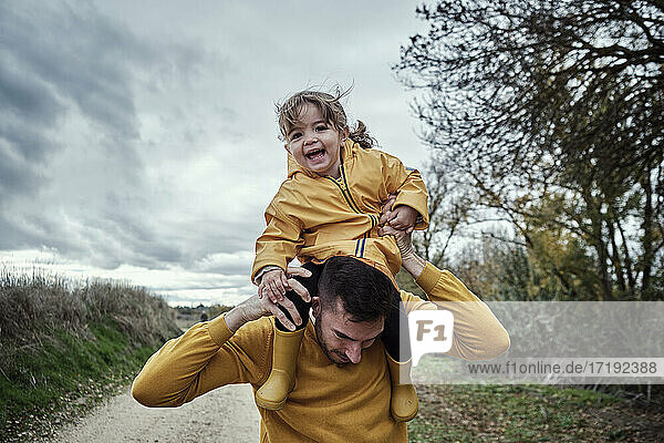 A two year old girl having fun with her dad in nature