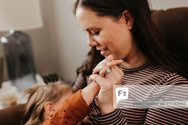 Mother breastfeeding toddler daughter in their living room