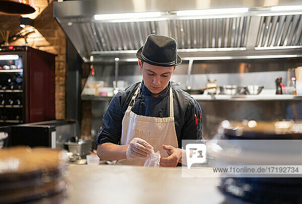 Junger Mann bereitet sich auf das Servieren von Essen in einem Café vor