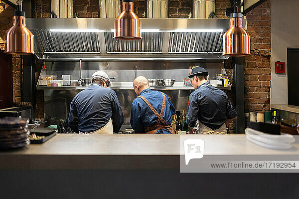 Unbekannte Männer arbeiten in der Küche eines Cafés
