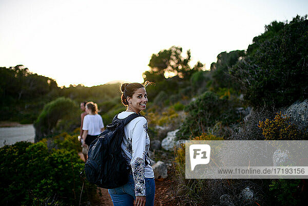 Glückliche junge Frau wandert mit Freunden auf Mallorca