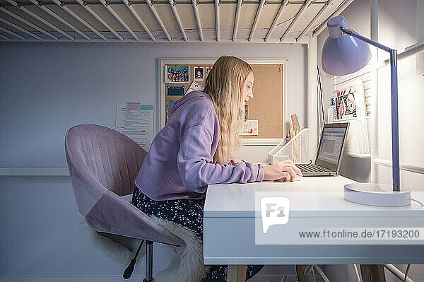 Tween Girl Sitting at Desk at Home Attending Remote School