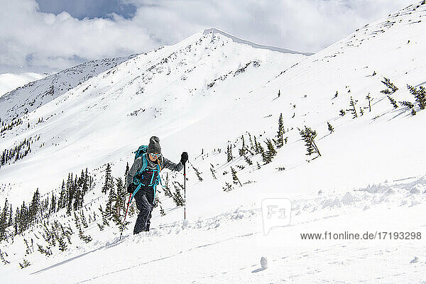 Junge Frau beim Skifahren auf einem schneebedeckten Berg im Urlaub