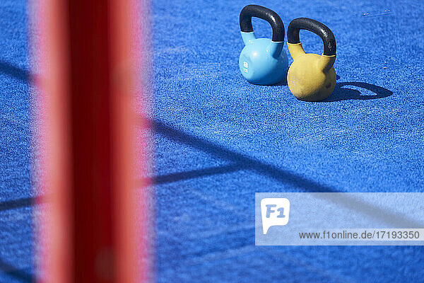 Blaue und gelbe Kesselglocke im Fitnessstudio im Freien