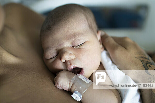 Ein Neugeborenes mit seiner jungen Mutter im Krankenhaus  das sich ausruht.