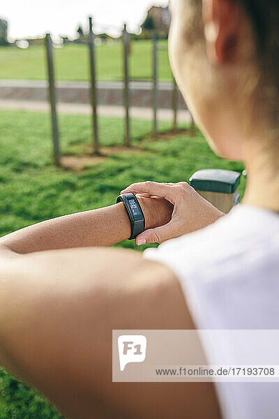 Unrecognizable athlete looking smartwatch outdoors