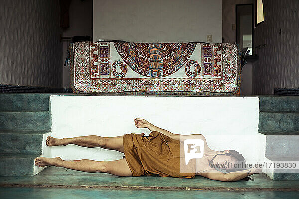 Attraktiver alternativer Mensch tanzt im heiligen Schlafzimmer mit Mayateppich