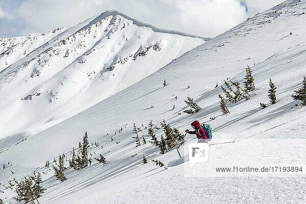 Frau beim Skifahren auf einem schneebedeckten Berg im Urlaub