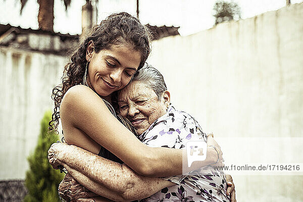 Mexikanische Frauen lächeln in liebevoller Umarmung auf der Sommerstraße in Mecxico
