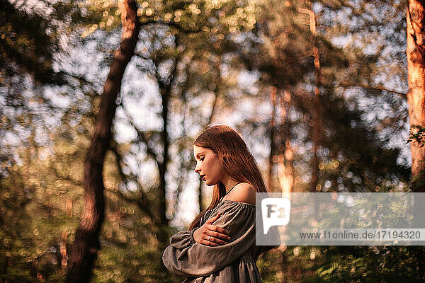 Seitenansicht eines nachdenklichen jungen Mädchens im Wald im Sommer