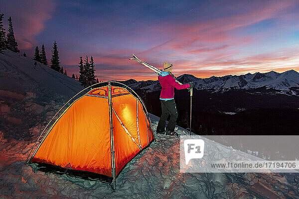 Woman camping on mountain during winter