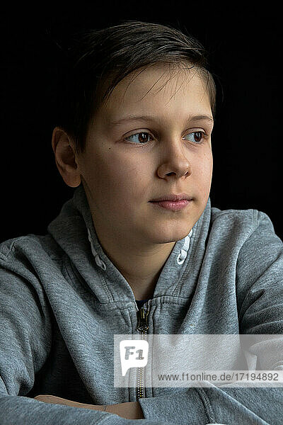 portrait of boy in front of black background