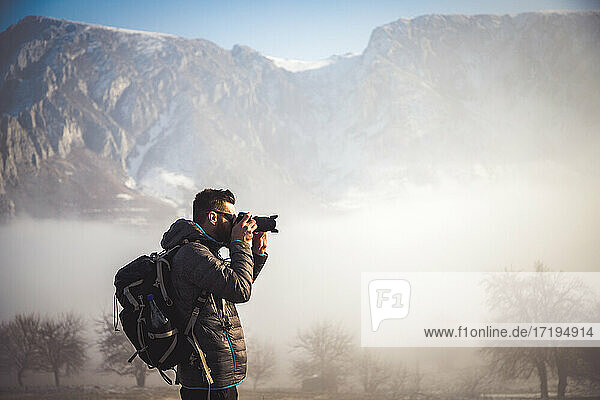 portrait of handsome man trekking in mountains in winter outdoo